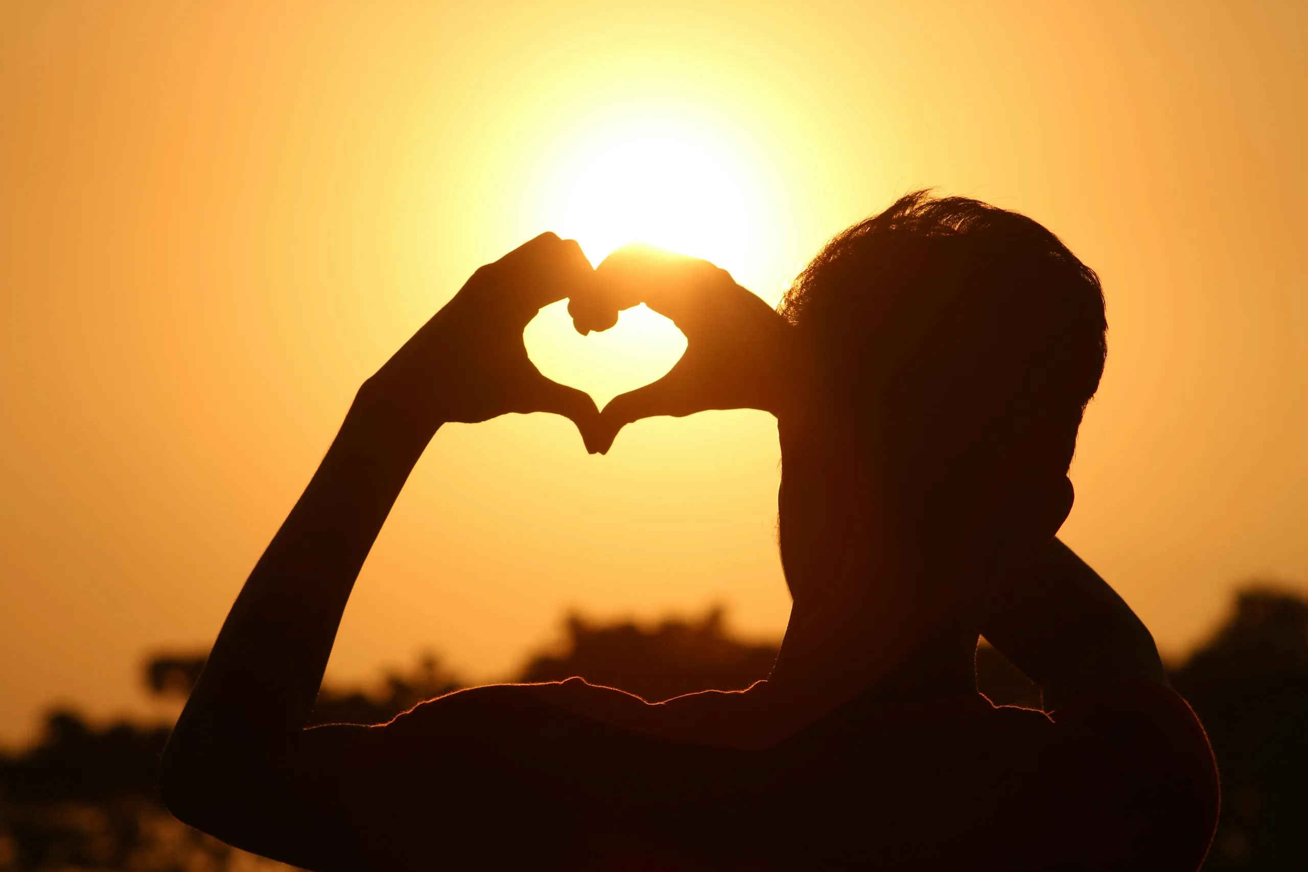 silhouette-photo-of-man-doing-heart-sign-during-golden-hour-712520-scaled